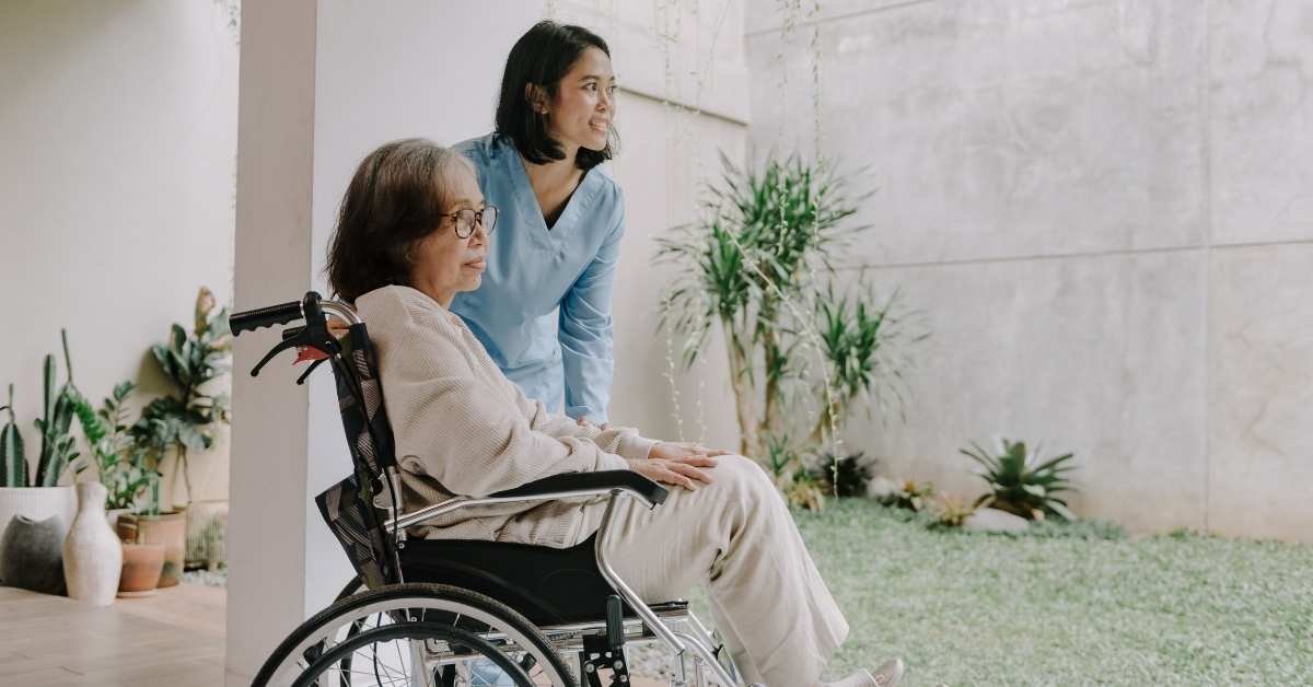 Caregiver helping an elderly woman in a wheelchair enjoy outdoor time at home in Ohio, showing compassionate medical and non-medical home care support